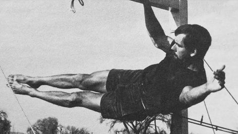 a man hanging upside down on a fingerboard